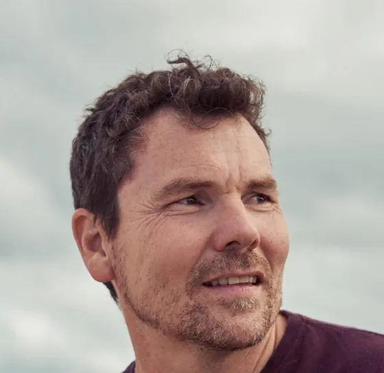 Leigh Houghton, smiling, outdoors under a cloudy sky